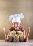 Happy chef child with pasta assortment and kitchen utensils