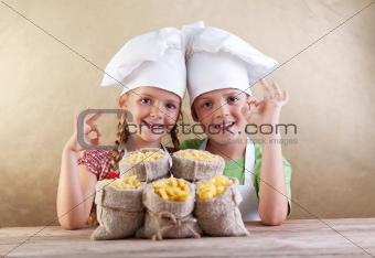 Kids with chef hats and pasta varieties - traditional food