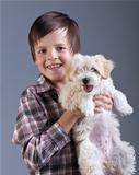 Happy boy holding his fluffy dog