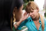 Woman having headache while talking with friend