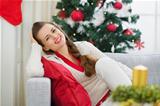 Portrait of happy young woman near Christmas tree