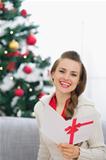 Smiling young woman with Christmas postcard