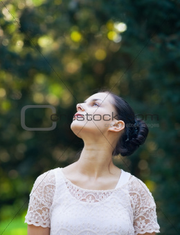 Thoughtful young woman in woods looking on 