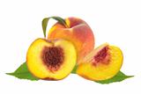 Fresh juicy peaches over green leaves isolated on white