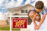 Happy Mixed Race Father and Son In Front of Sold Real Estate Sign and New House.