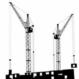 Silhouette of two cranes working on the building