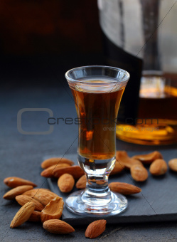 Almond liquor amaretto with whole nuts on a dark background