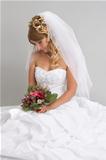 Beautiful bride with stylish make-up and hairdo holding bouquet 