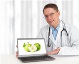 doctor showing green apples on his laptop computer