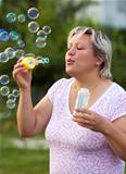Woman blowing bubbles outdoors