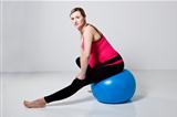 Pregnant woman stretching with fitness ball