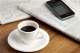 Coffe cup, smartphone and newspapers.