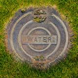 Water Manhole Cover in Grass