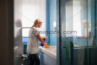 Young woman doing chores and cleaning bathroom at home