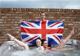 Three people with a union jack in a jacuzzi
