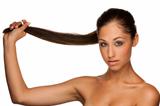 Portrait of cute caucasian brunette girl holding her hair in han