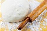 rolling pin with pizza dough