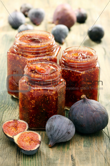 Figs and homemade jam in glass jars. 