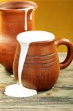 Ceramic mug with cream and clay jug.
