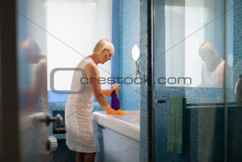 Active retired woman doing chores and cleaning bathroom at home