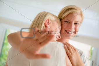 Young happy woman showing engagement ring to her mom