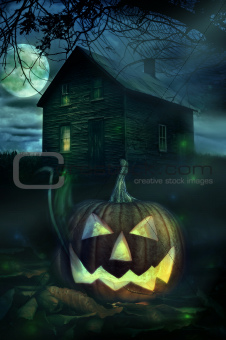 Halloween pumpkin in front of a Spooky house