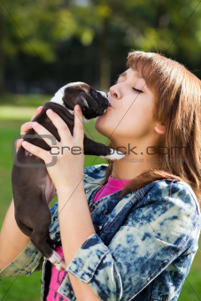 Girl kissing her puppy