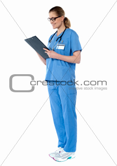 Female surgeon with stethoscope, reading report