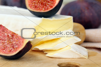 Brie cheese and sweet fruit  figs on a wooden board