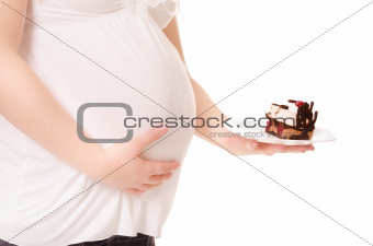 Pregnant woman hold a sweet cake on a plate.