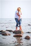 couple embrace on a stone in sea