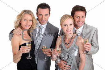 Double date: couples in party dress drinking champagne