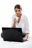 Girl drinking a tea in front of laptop