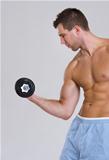 Muscular man workout biceps with dumbbell
