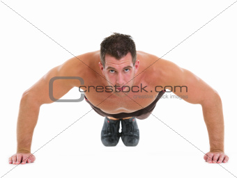 Muscular man making push up exercises