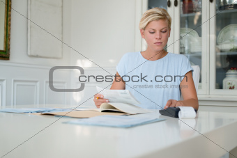 Young woman checking bills and doing budget at home