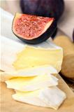 Brie cheese and sweet fruit  figs on a wooden board