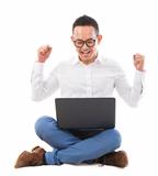 Excited Asian man using laptop