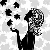 Silhouette of young woman with flying leaves