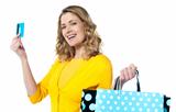 Attractive woman holding cerdit-card with shopping bags