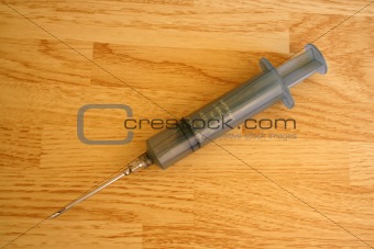 Meat flavor injector on a wooden table