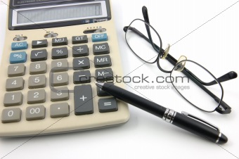 Eyeglasses, pen and calculator
