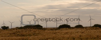 Line of wind power generators on the sky background