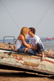 couple sitting on old boat and kiss