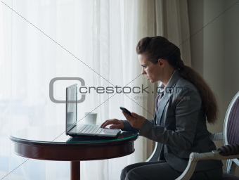 Business woman working on laptop in hotel room