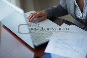 Closeup on business woman working with documents and laptop