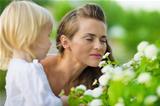 Mother and baby enjoying flowers outdoors