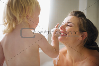 Mother playing with baby in bathtub