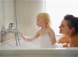 Mother and baby playing in bathtub