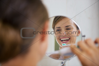 Happy woman brushing teeth with electric toothbrush